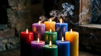 Colorful burning candles with smoke creating atmospheric mood lighting for relaxation, meditation, aromatherapy and spiritual wellness practices.