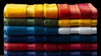 Colorful stacked bath towels in vibrant rainbow shades against black background, folded neatly showing texture and layers. Clean fresh spa and bathroom concept.