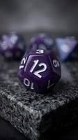 Purple polyhedral dice set with metallic numbers on stone surface, ideal for tabletop gaming, role-playing games, and fantasy adventures.