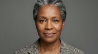 Professional African American senior businesswoman with gray hair in corporate blazer against neutral background for executive portraits and diversity campaigns.