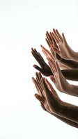 Multiple diverse hands reaching upward in unity gesture on white background for teamwork and collaboration concepts.