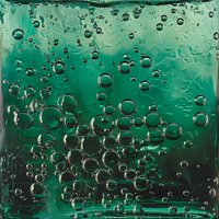 Air bubbles rising through emerald green liquid create dynamic abstract pattern with transparent spheres and light reflections in macro photography.