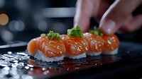 Fresh salmon nigiri sushi garnished with green onions and sesame seeds on black plate, dramatic lighting creates reflection, close-up food photography.