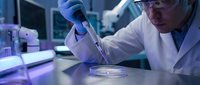 Scientist in white lab coat and blue gloves conducting research with pipette in modern laboratory setting. Suitable for healthcare, biotechnology, and scientific research projects.
