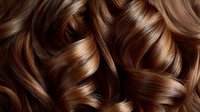 Luxurious brown wavy hair with highlights close-up showing healthy, shiny curls and professional styling texture. Natural brunette hair with caramel balayage tones.