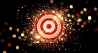 Glowing red and white target bullseye with golden sparks and bokeh lights on dark background for business goals and achievement concepts.