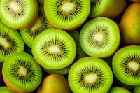 Fresh kiwi fruit slices arranged in rows showing bright green flesh and distinctive seed pattern, creating natural geometric pattern for food photography.