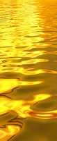 Shimmering golden liquid surface with rippling waves and reflective patterns creates luxurious metallic texture for elegant backgrounds and luxury designs.