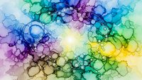 Vibrant alcohol ink abstract with flowing organic bubbles and circles in rainbow spectrum from yellow center radiating to purple, blue and green edges.