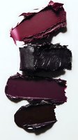 Smeared dark lipstick swatches in burgundy, black, and deep purple shades showing rich creamy texture and pigmentation against white background for cosmetic marketing.