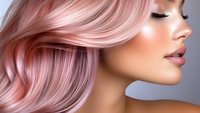 Side profile close up with flowing rose gold hair, glossy lips, and flawless makeup against gray background. For beauty, fashion and hair salon advertising.
