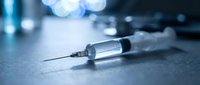 Medical syringe with needle on sterile surface in clinical laboratory environment for healthcare injection procedures and pharmaceutical treatments.
