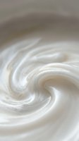 Creamy white swirl texture with smooth flowing curves and soft beige tones creating elegant abstract pattern for luxury cosmetic and skincare product backgrounds.