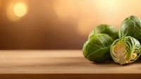 Fresh green Brussels sprouts on wooden table with warm golden sunlight background for healthy cooking and nutrition concepts.
