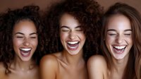 Three diverse young women laughing together with genuine joy and happiness, showing friendship and positive emotions in warm lighting.