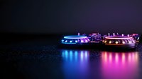 Glowing gaming controllers with neon blue and pink light reflection on dark surface create atmospheric cyberpunk mood for entertainment background.