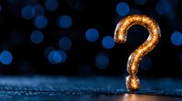 Glowing golden question mark against dark blue bokeh background with sparkle effect creates mysterious and contemplative mood for business concepts.