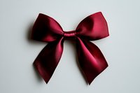 Elegant burgundy satin bow isolated on white background. Classic decorative ribbon knot with symmetrical loops for gift wrapping, fashion, and holiday designs.