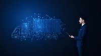 Caucasian businessman in navy suit interacting with holographic truck projection showing digital transformation in logistics and supply chain technology on dark background.