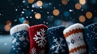 Cozy winter socks with snowflake patterns and warm knit designs against dark background with bokeh lights and falling snow creating festive holiday atmosphere.