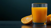 Fresh orange juice in glass with sliced citrus fruit on dark background, healthy vitamin drink with natural ingredients for breakfast menu.