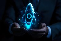 Glowing blue holographic rocket floating above businessman hands in dark setting, representing startup, innovation and business growth concept.