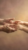 Elderly and young hands reaching toward each other in warm golden light symbolizing intergenerational connection, care, support and family bonds.