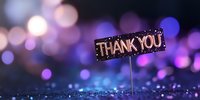 Glowing thank you sign on sparkly surface against purple and blue bokeh background, creating magical atmosphere for gratitude expression.