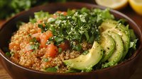 Healthy quinoa bowl with fresh avocado slices, mixed greens, diced tomatoes and sesame seeds in wooden bowl for nutritious meal planning and clean eating.