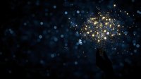 Silhouette of hand reaching for glowing golden light particles against dark blue bokeh background, creating magical atmosphere.