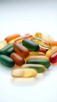 Colorful vitamin supplements and capsules scattered on white background for health and wellness nutrition concepts.