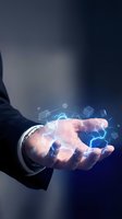 Businessman holding glowing digital cubes and electric energy in open palm against dark blue background, representing technology innovation and data management.