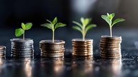 Growing green plants on stacks of coins showing increasing height, representing sustainable financial growth, investment returns and economic development.