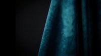 Luxurious teal velvet fabric with rich texture and elegant draping against dark background for premium interior design and fashion projects.