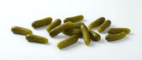Scattered pickled gherkins and dill cucumbers isolated on white background, ready for food packaging, recipe blogs, restaurant menus, and culinary design projects.