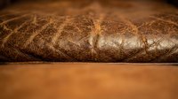 Luxurious brown leather upholstery with detailed stitching and rich texture for furniture design and interior decoration projects.