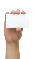 Hand holding blank white business card mockup isolated on white background for branding and marketing design projects.
