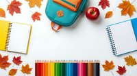 School supplies with colorful pencils, notebooks, backpack and apple surrounded by autumn leaves on white background for back to school season.