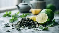 Fresh green tea leaves with lime, lemon and mint on rustic surface, creating aromatic beverage ingredients for healthy detox drinks.