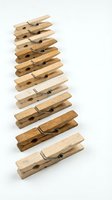 Stack of wooden clothespins arranged vertically on white background showing natural wood grain textures for laundry and craft projects.