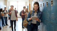 Young Hispanic female student using digital tablet in school hallway with blue lockers and diverse classmates in background for education technology concepts.