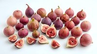 Fresh figs collection with whole and sliced fruits showing pink flesh on white background. Organic Mediterranean produce for healthy eating and cooking.