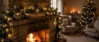 Cozy living room with a stone fireplace decorated with pine garland, pinecones, fairy lights, and a Merry Christmas sign during the holiday season.