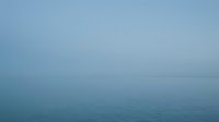 Serene ocean seascape with calm waters and misty horizon, suitable for backgrounds, wellness, meditation, and travel design projects.