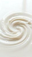 Creamy white swirl texture with smooth spiral pattern and soft highlights, suitable for cosmetics, skincare, dairy, and food product backgrounds.