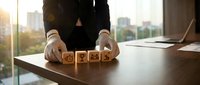 Professional businessman arranging wooden blocks with star rating symbols on office desk, representing customer feedback and quality assessment concepts.