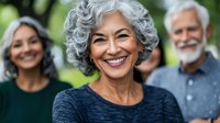 Mature woman with gray curly hair and bright smile leading active senior lifestyle outdoors with friends, wellness and aging concept for healthcare.