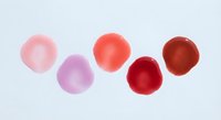 Watercolor paint drops in pink and red tones on white background. Abstract artistic spots for creative design projects and decorative elements.