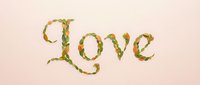 Floral love lettering with green leaves and flowers on soft pink background for romantic designs, wedding invitations and Valentine's Day decorations.