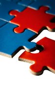 Red and blue jigsaw puzzle pieces interlocking on white background, representing problem solving, teamwork, connection, and business strategy solutions.
